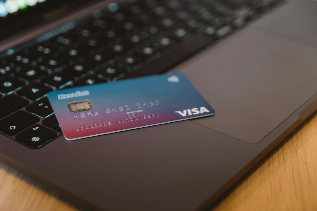 visa credit card sitting on top of a grey laptop